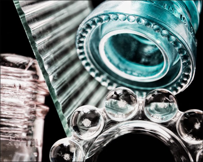 Sixth abstract composition from the "An Abyss of Glass" project, a fourteen-image series featuring various glass objects, intricate dynamic highlights and shadows, arranged to create a sense of depth, tension, and visual illusion.