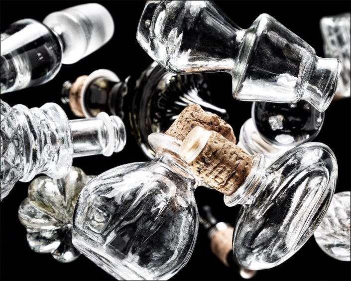 First abstract composition from the "An Abyss of Glass" project, a fourteen-image series featuring various glass objects, intricate dynamic highlights and shadows, arranged to create a sense of depth, tension, and visual illusion.