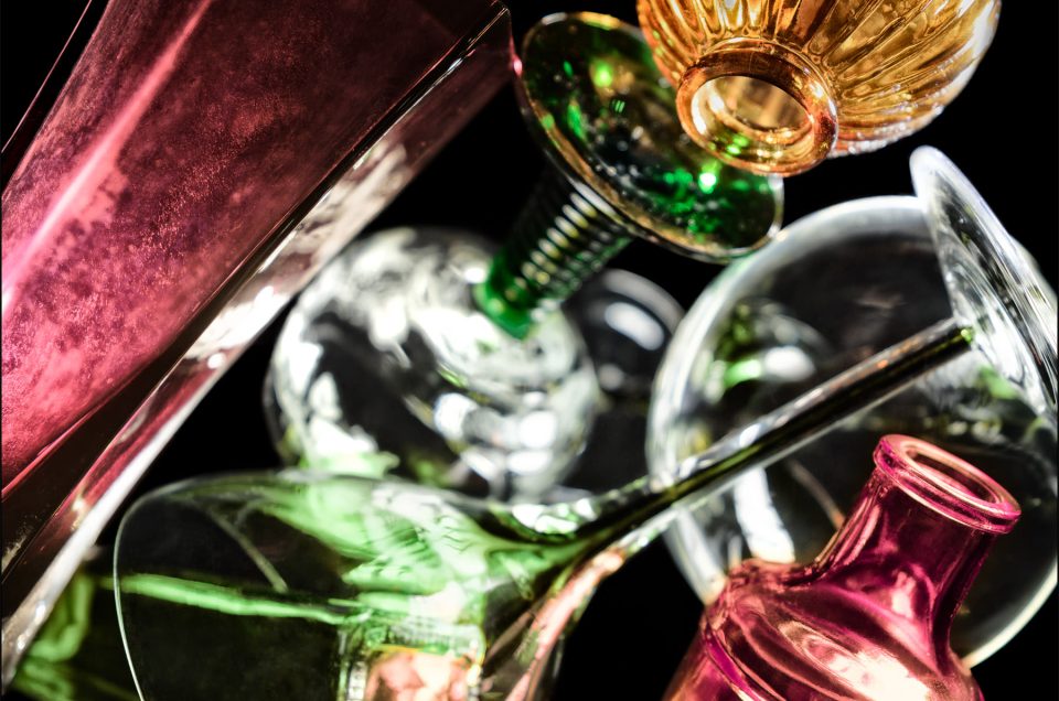 Tenth abstract fine art photo from the ten-image series, "An Abyss of Glass & Color" which features vivid colors, highlights, and shadows on various layered glass objects. Captured from below, the image creates a sense of depth from the layered space by blending form, light, and color to evoke a vibrant, infinite void.