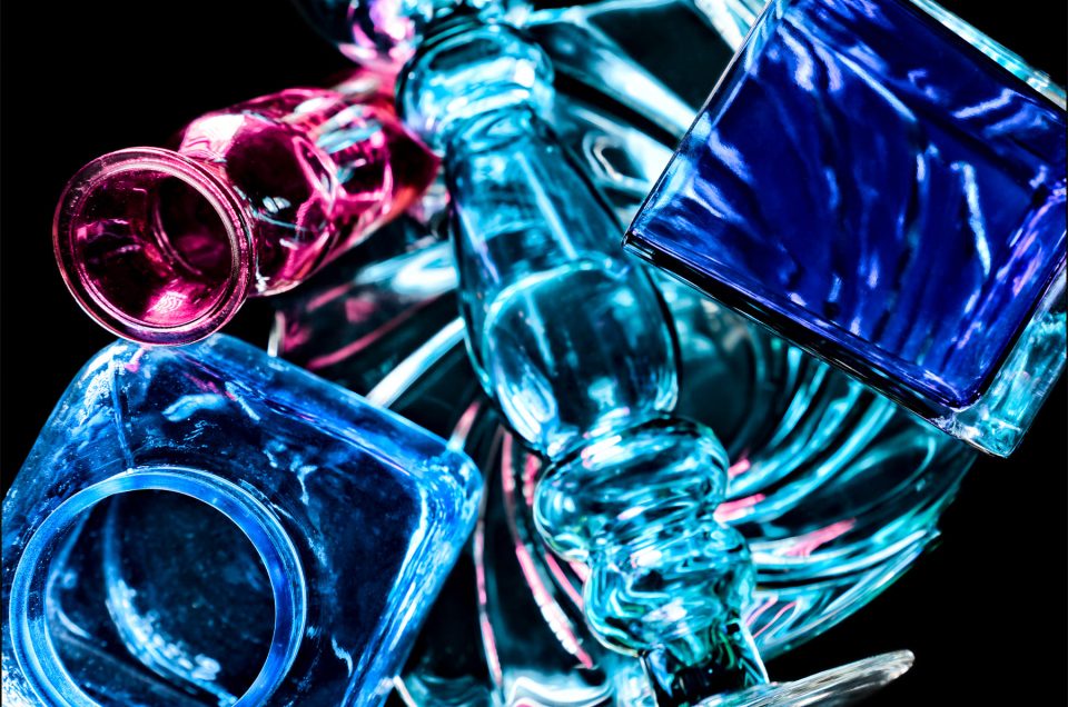 Fifth abstract fine art photo from the ten-image series, "An Abyss of Glass & Color" which features vivid colors, highlights, and shadows on various layered glass objects. Captured from below, the image creates a sense of depth from the layered space by blending form, light, and color to evoke a vibrant, infinite void.