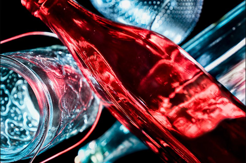 Eighth abstract fine art photo from the ten-image series, "An Abyss of Glass & Color" which features vivid colors, highlights, and shadows on various layered glass objects. Captured from below, the image creates a sense of depth from the layered space by blending form, light, and color to evoke a vibrant, infinite void.