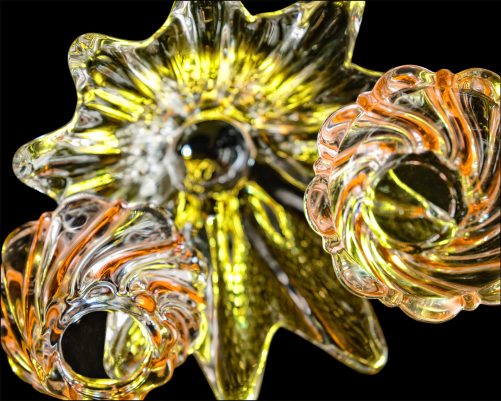 Seventh abstract fine art photo from the ten-image series, "An Abyss of Glass & Color" which features vivid colors, highlights, and shadows on various layered glass objects. Captured from below, the image creates a sense of depth from the layered space by blending form, light, and color to evoke a vibrant, infinite void.